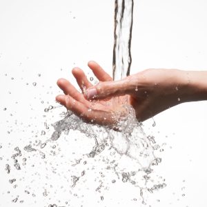 closeup-woman-hand-stream-splashing-water-skin-care-concept